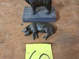 une petite statue représentant un chien et un cochon, posée sur une table