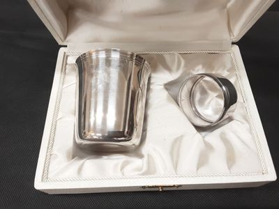 a silver cup in a box on a black surface