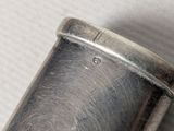 a silver object on a table with a white background