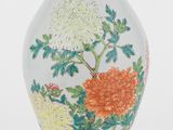 un vase avec des fleurs peintes dessus, posé sur une table