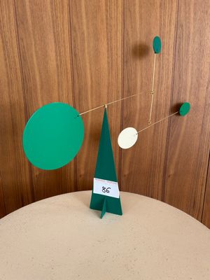 a green and white mobile with a christmas tree on top of it
