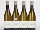 trois bouteilles de vin blanc posées les unes à côté des autres sur une table