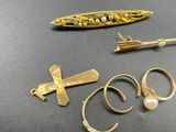several gold rings, a gold arrow, and a ring with a pearl