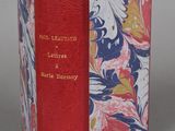 an old book with a red cover and a floral design