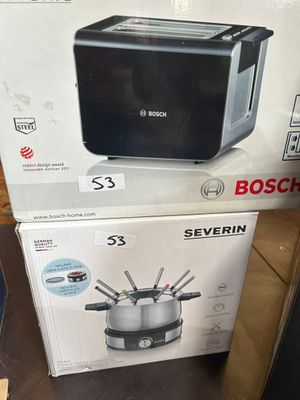 deux cartons contenant des appareils électroménagers posés sur une table dans un magasin