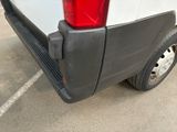 the rear end of a white van with a red tail light