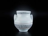 un vase blanc orné d'un motif noir et blanc