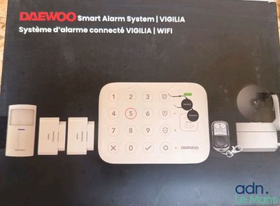 La boîte est ouverte, dévoilant le contenu d'un système d'alarme intelligent.