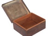 a small wooden box with a metal lid on a white surface