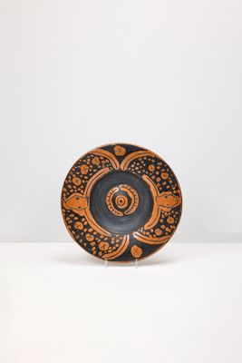 une assiette orange et noire posée sur une table blanche