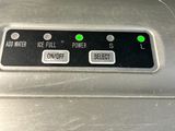 a close up of a toaster with green buttons on it