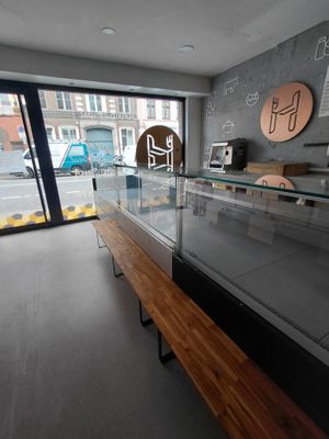 une vitrine en verre avec un banc en bois devant