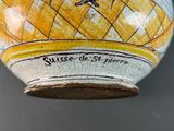 a yellow and white vase with a bird on it