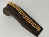 a close up of a gold chain bracelet on a wooden block