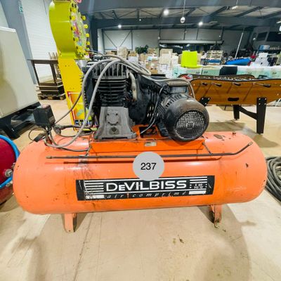 un compresseur d'air orange posé sur une table dans une pièce
