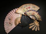 several different types of hand fans on a black surface