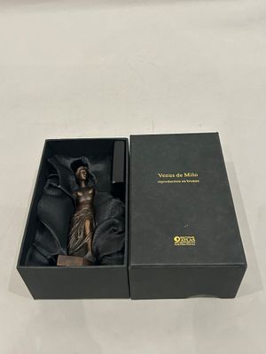 a black box with a statue in it on a table