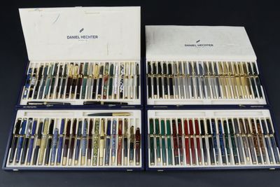 deux jeux de stylos et une boîte de stylos posés sur une table