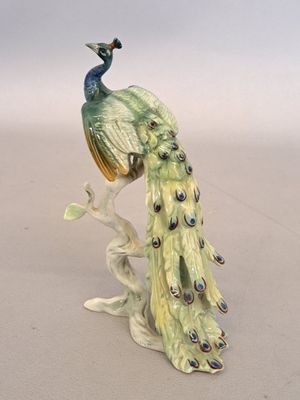 a figurine of a peacock sitting on a branch