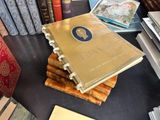 a stack of books sitting on a table next to a pile of books