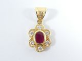 un pendentif en or jaune serti d'un rubis entouré de diamants