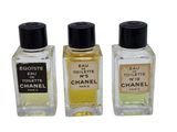 three bottles of perfume sitting next to each other on a white surface