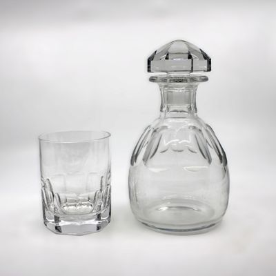un verre et une carafe posés l'un à côté de l'autre