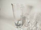 many glasses and a pitcher sitting on a table