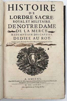 un vieux livre dont la couverture arbore un blason