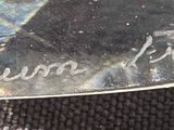 a close up of a silver plate with a picture of a man