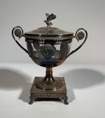 an antique silver plated trophy on a stand with a bird on top