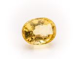 a yellow sapphire stone on a white background