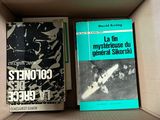 two books in a cardboard box on a white surface
