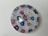 une assiette en verre décorée de fleurs, posée sur une table
