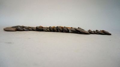 a long stick made out of rocks on a white surface