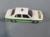 a toy police car sitting on a table next to another toy car