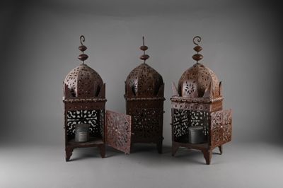 trois lanternes en métal ornées de motifs complexes sur fond gris