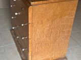 une photo d'une commode en bois posée sur un sol carrelé