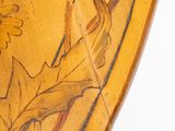 a close up of a wooden table with a painting on it