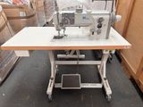 une machine à coudre posée sur une table dans un entrepôt