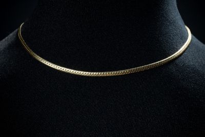 un collier ras-du-cou en or sur un mannequin, un mannequin, un mannequin, un mannequin, un mannequin, un mannequin, un mannequin, un mannequin, un manne