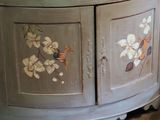 a cabinet with flowers painted on it in a room