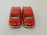 two red toy cars connected to a white cord