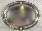 a silver plate on a white table with a wall in the background