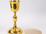 une coupe en or posée à côté d'un miroir sur une table