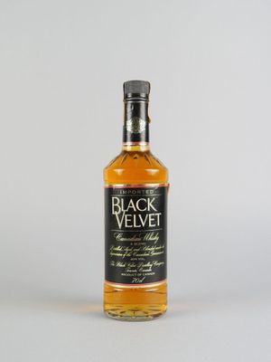 une bouteille de whisky « Black Velvet » posée sur une surface blanche