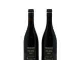 two bottles of wine sitting next to each other on a white surface
