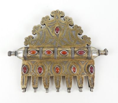 une image représentant un peigne en argent et en or orné de pierres rouges