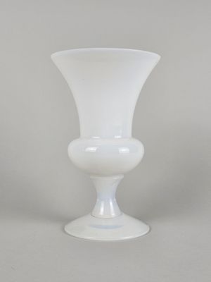 un vase en verre blanc posé sur une table blanche