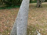 a stone sculpture in the middle of a field of leaves